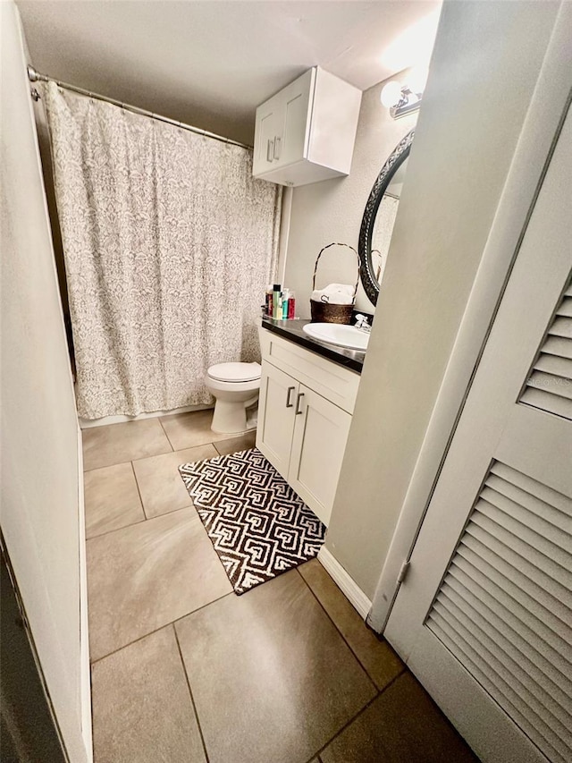 bathroom with tile patterned flooring, vanity, and toilet