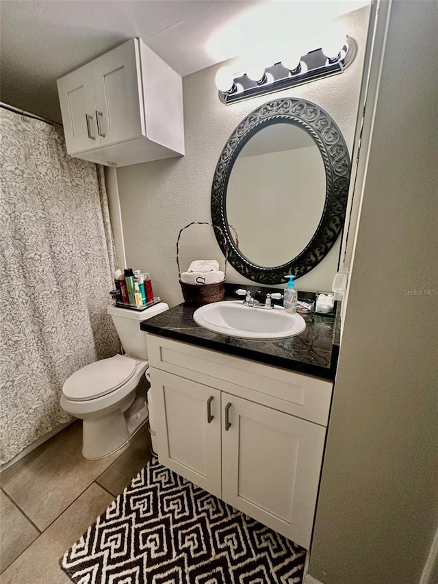 bathroom featuring tile patterned floors, vanity, and toilet