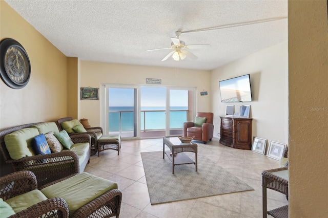 tiled living room with ceiling fan and a textured ceiling