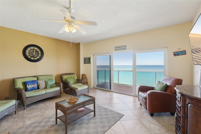 tiled living room with ceiling fan and a textured ceiling