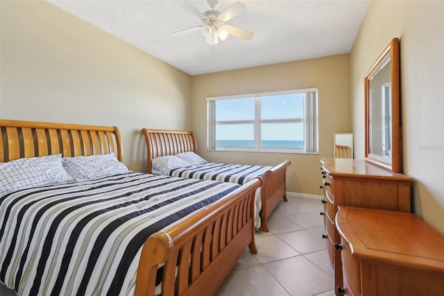 tiled bedroom with ceiling fan and a textured ceiling