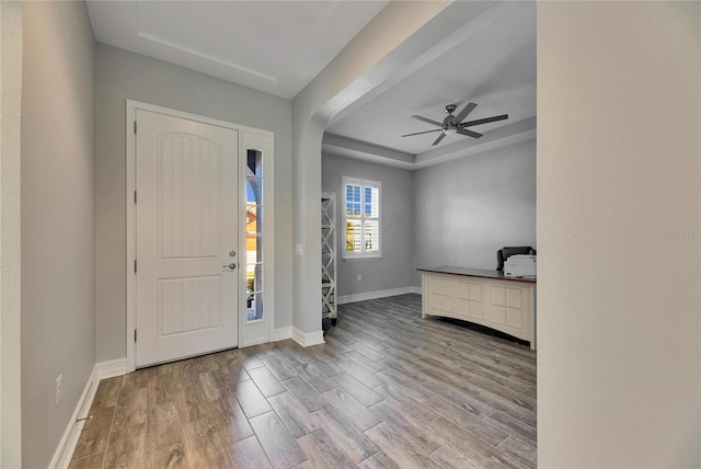 foyer entrance featuring a raised ceiling, hardwood / wood-style floors, and ceiling fan