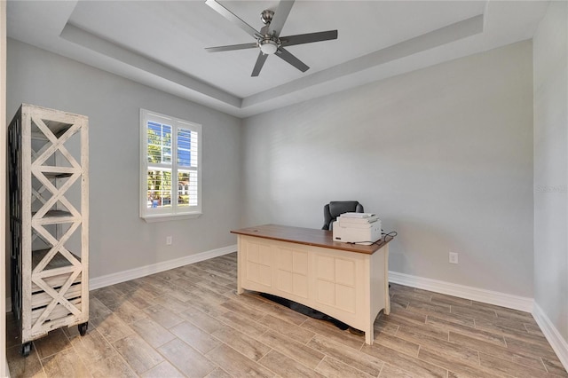 office with a raised ceiling and ceiling fan