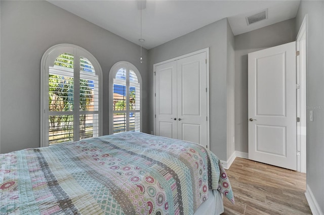 bedroom with ceiling fan, a closet, and light hardwood / wood-style floors