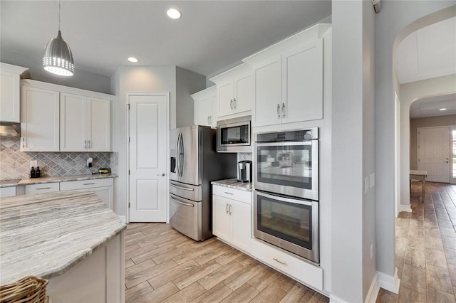 kitchen with light stone countertops, white cabinetry, and appliances with stainless steel finishes