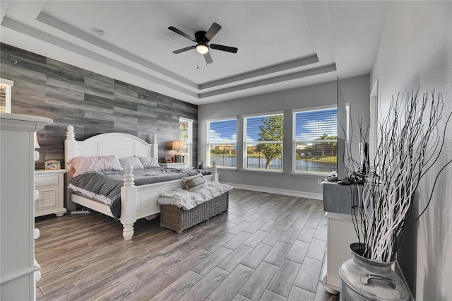 bedroom with a raised ceiling and ceiling fan