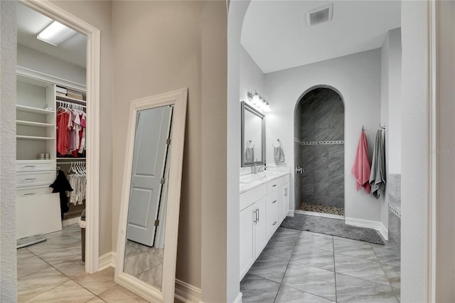 bathroom featuring a tile shower and vanity