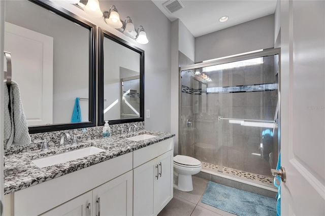 bathroom with vanity, a shower with shower door, tile patterned floors, and toilet