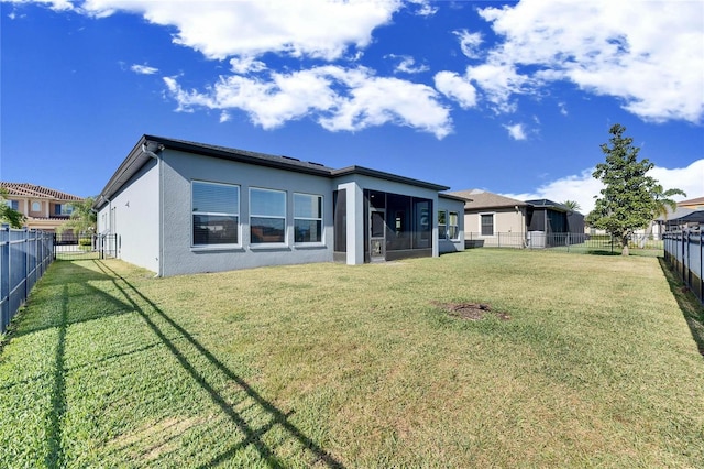 rear view of property with a yard and a sunroom