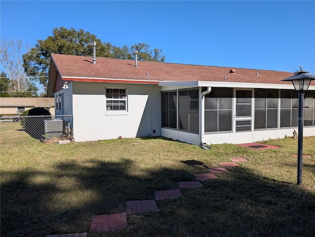 rear view of property featuring a sunroom and a yard