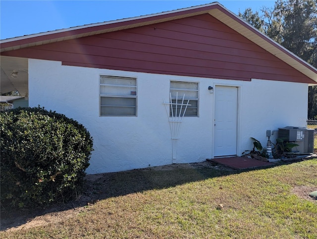 exterior space featuring a lawn and central AC unit