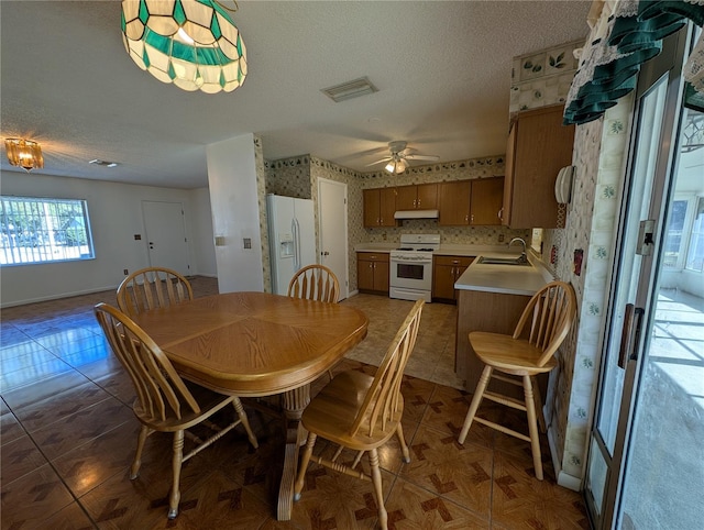 dining room with a textured ceiling, ceiling fan, and sink