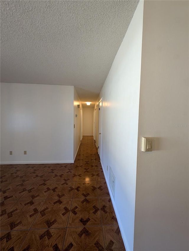 hall featuring a textured ceiling