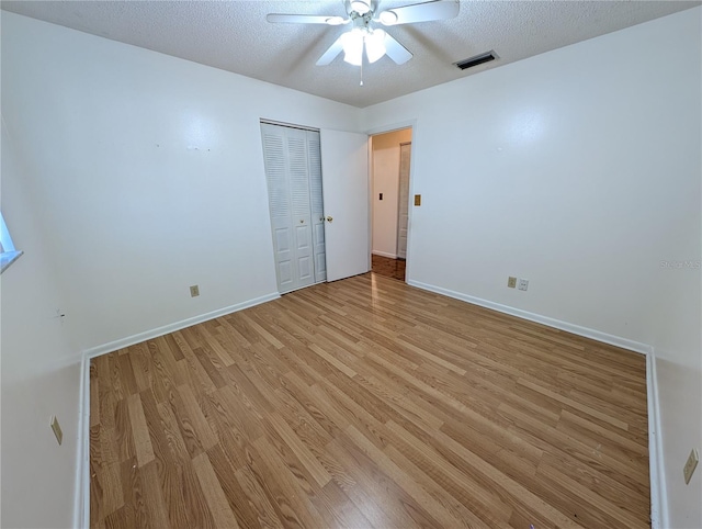 spare room featuring ceiling fan, a textured ceiling, and light hardwood / wood-style flooring