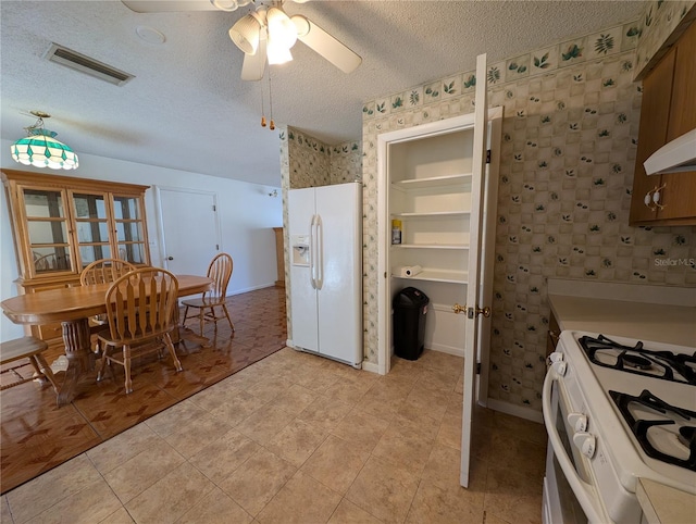 kitchen featuring ceiling fan, built in features, white appliances, and a textured ceiling