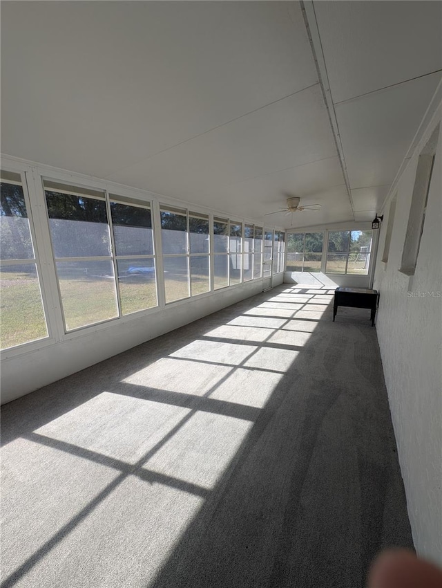 unfurnished sunroom featuring ceiling fan