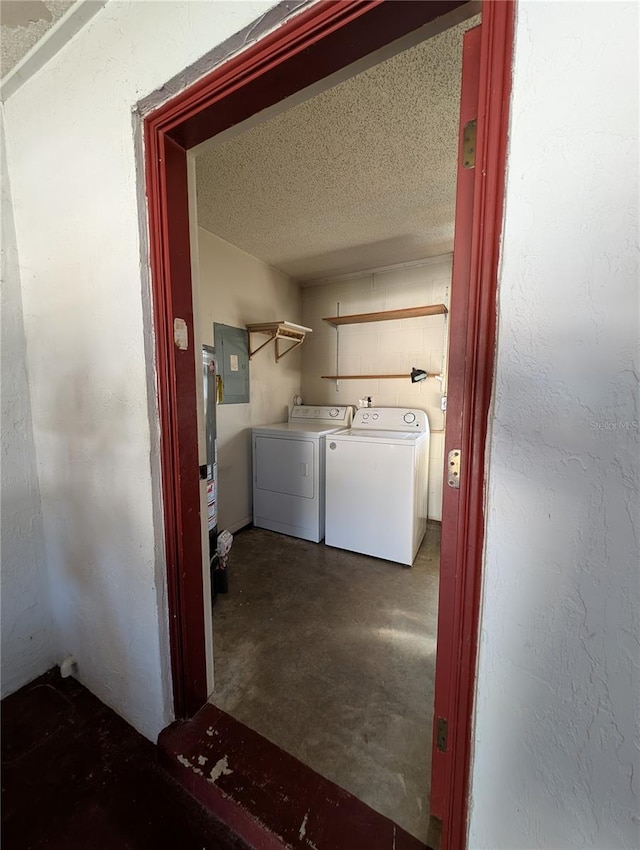 washroom with electric panel, water heater, washer and clothes dryer, and a textured ceiling