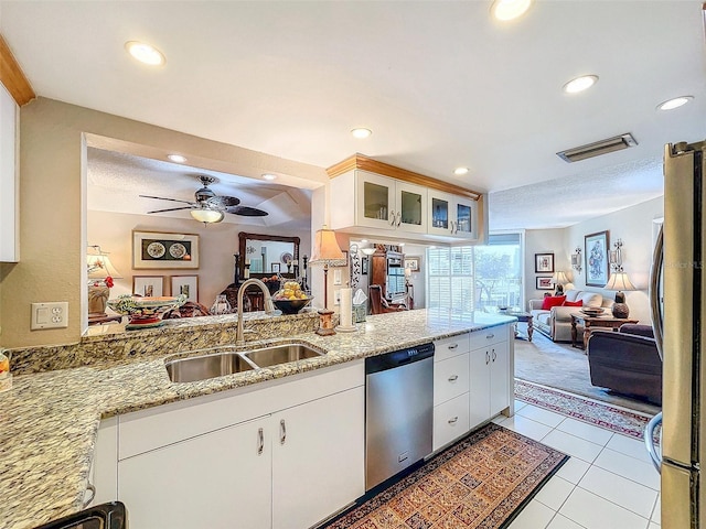 kitchen featuring light stone counters, sink, white cabinets, and stainless steel appliances