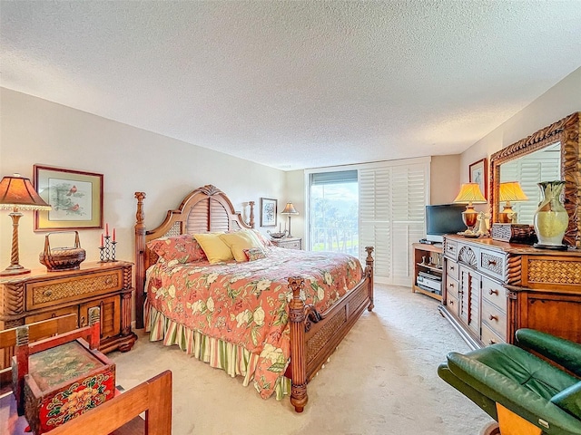 bedroom with a textured ceiling and light colored carpet