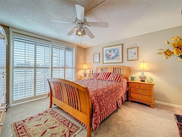 carpeted bedroom with ceiling fan and a textured ceiling