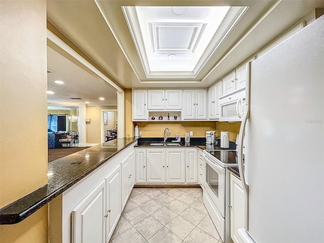 kitchen with a tray ceiling, kitchen peninsula, white cabinetry, and white appliances