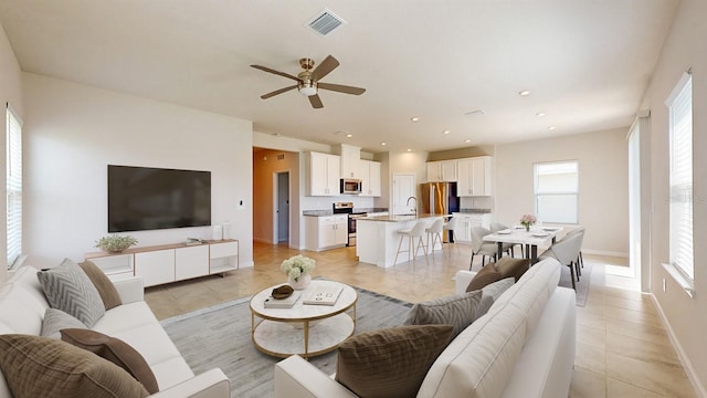 tiled living room with ceiling fan