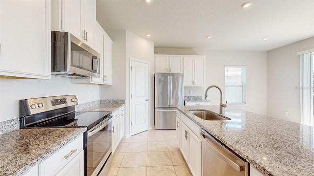 kitchen featuring white cabinetry, light stone countertops, sink, stainless steel appliances, and light tile patterned floors