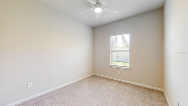 spare room with ceiling fan and light carpet