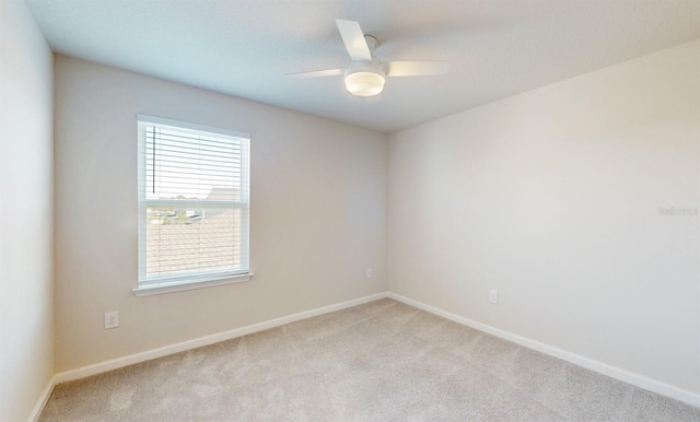 spare room featuring light carpet and ceiling fan