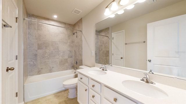 full bathroom featuring vanity, tiled shower / bath combo, and toilet