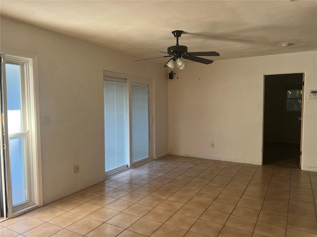 spare room with ceiling fan and light tile patterned floors