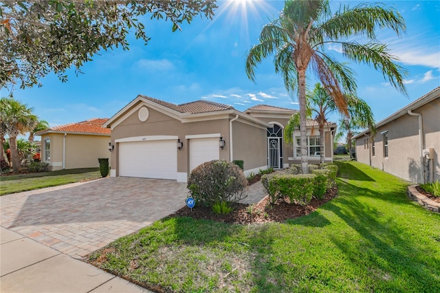 mediterranean / spanish-style home featuring a front lawn and a garage