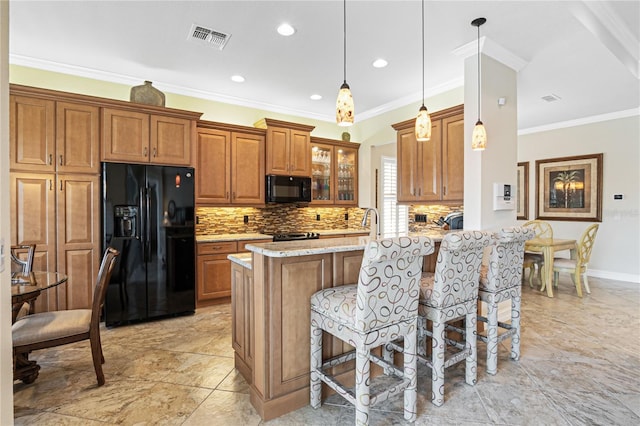 kitchen with black appliances, decorative light fixtures, light stone countertops, and crown molding