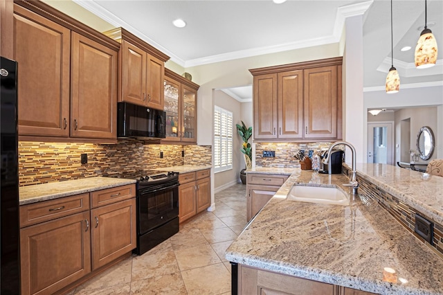 kitchen with black appliances, crown molding, sink, hanging light fixtures, and light stone counters