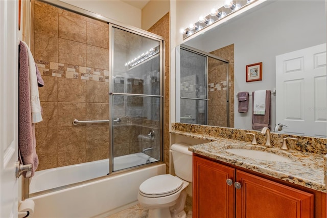 full bathroom featuring combined bath / shower with glass door, vanity, and toilet