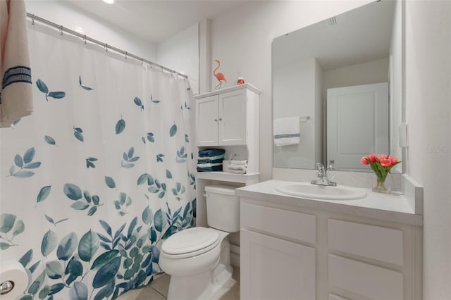 bathroom featuring tile patterned flooring, vanity, toilet, and walk in shower