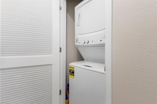 clothes washing area featuring stacked washer and clothes dryer