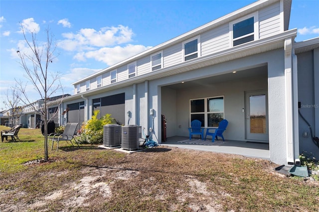 view of front of property with central AC unit, a patio area, and a front lawn