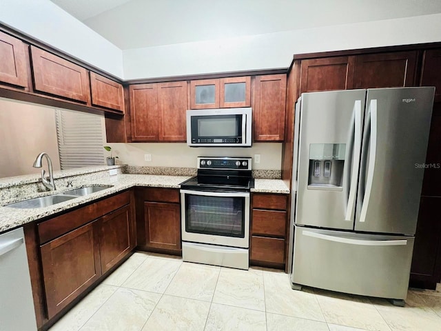 kitchen featuring light stone countertops, sink, and appliances with stainless steel finishes