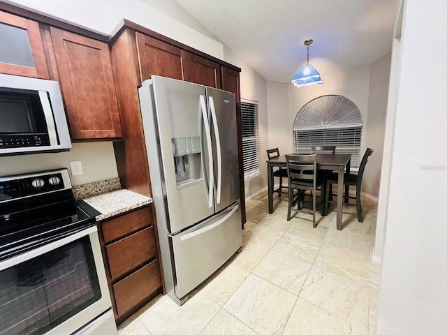 kitchen featuring light stone countertops, white appliances, and decorative light fixtures