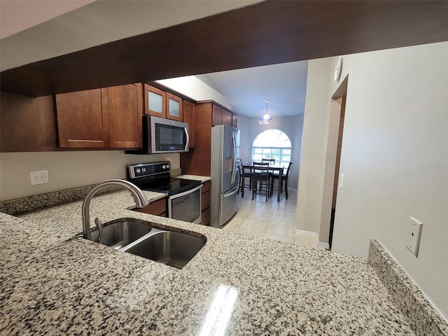 kitchen featuring light tile patterned floors, stainless steel appliances, light stone countertops, and sink