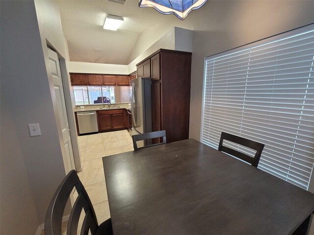 unfurnished dining area featuring vaulted ceiling and sink