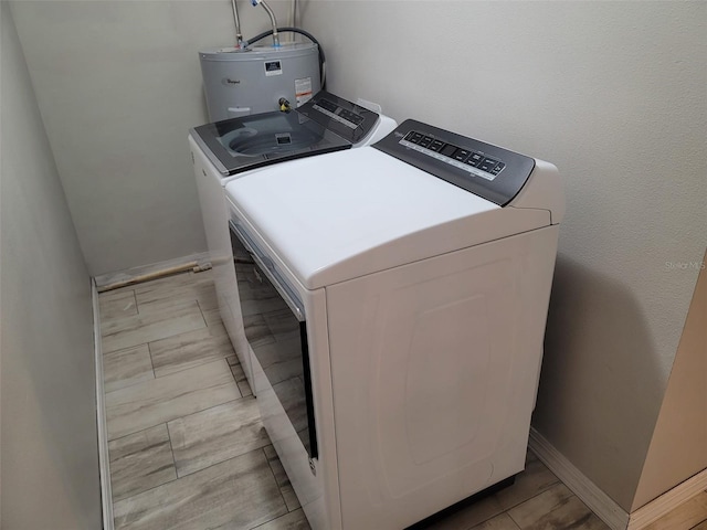 clothes washing area featuring washing machine and clothes dryer and water heater