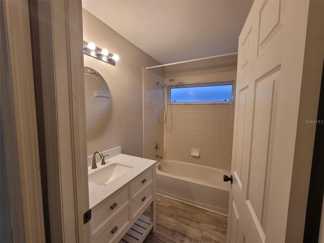 bathroom with tiled shower / bath combo and vanity