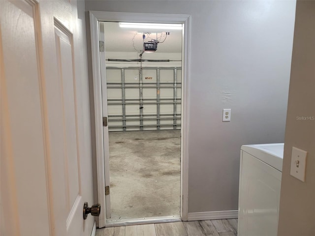 clothes washing area with washer / clothes dryer and light hardwood / wood-style flooring