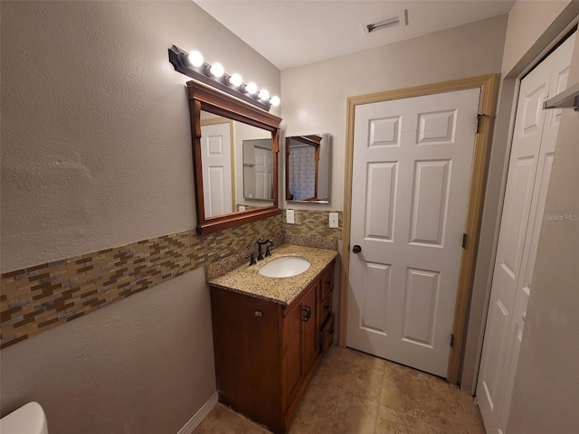 bathroom featuring vanity and tasteful backsplash