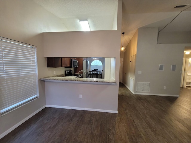 kitchen featuring appliances with stainless steel finishes, hanging light fixtures, dark wood-type flooring, light stone counters, and kitchen peninsula