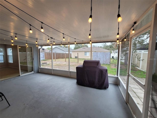 unfurnished sunroom with plenty of natural light and rail lighting