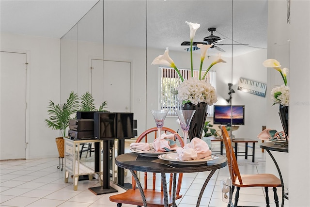 dining space with a textured ceiling, ceiling fan, and light tile patterned flooring