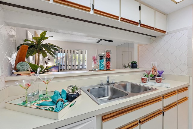 kitchen with decorative backsplash, white cabinetry, and sink